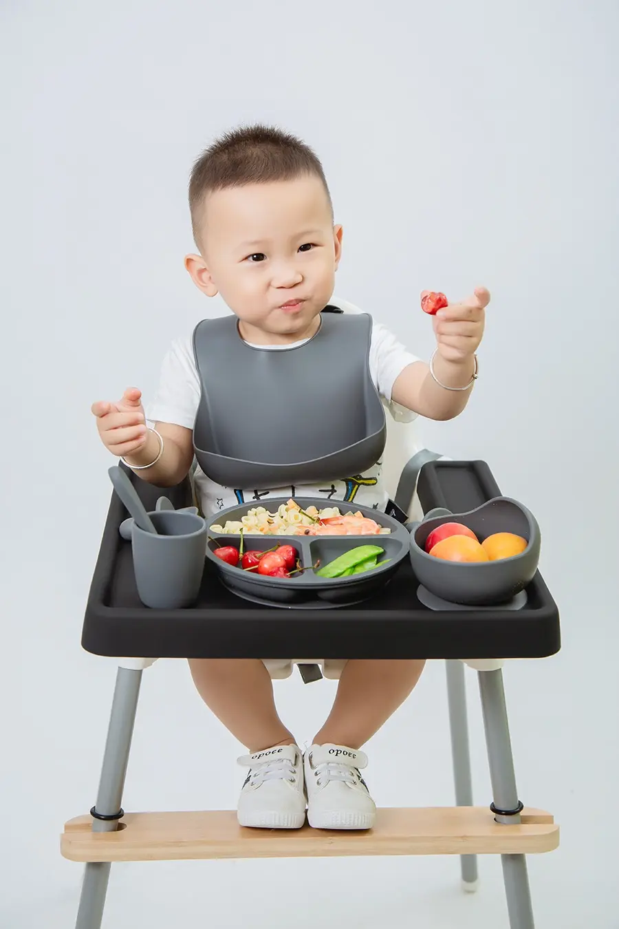 Baby seated in an IKEA Antilop high chair with SANNYIN silicone accessories